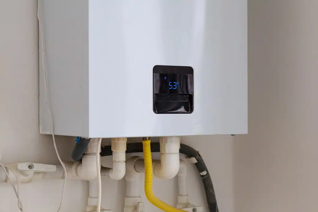 Tankless water heater installed on a white wall.