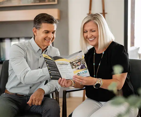 Texas homeowners holding a Frymire brochure